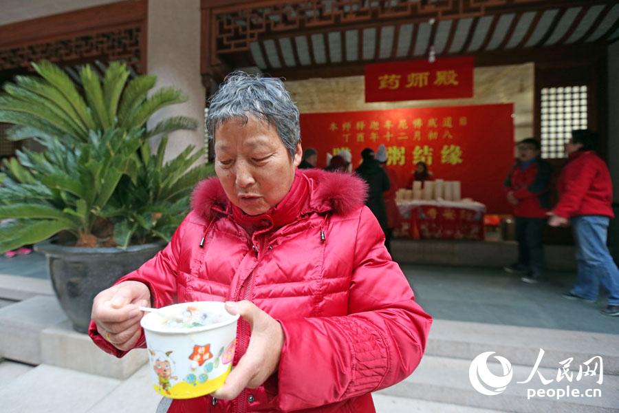 市民朱阿姨展示刚领取到的腊八粥。