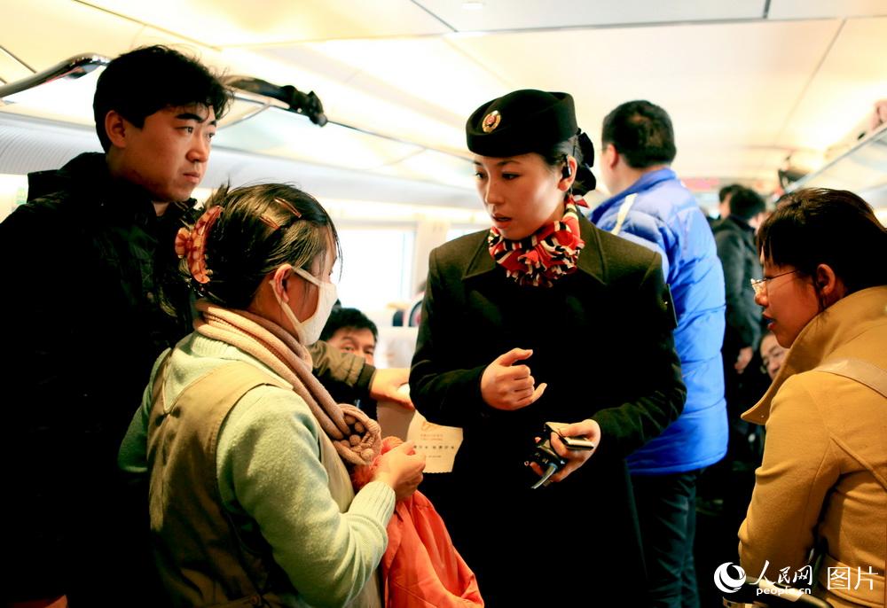 2010年1月3日，天津客运段京津城际列车乘务员向旅客介绍北京站换乘车次时间。 高锦旭摄