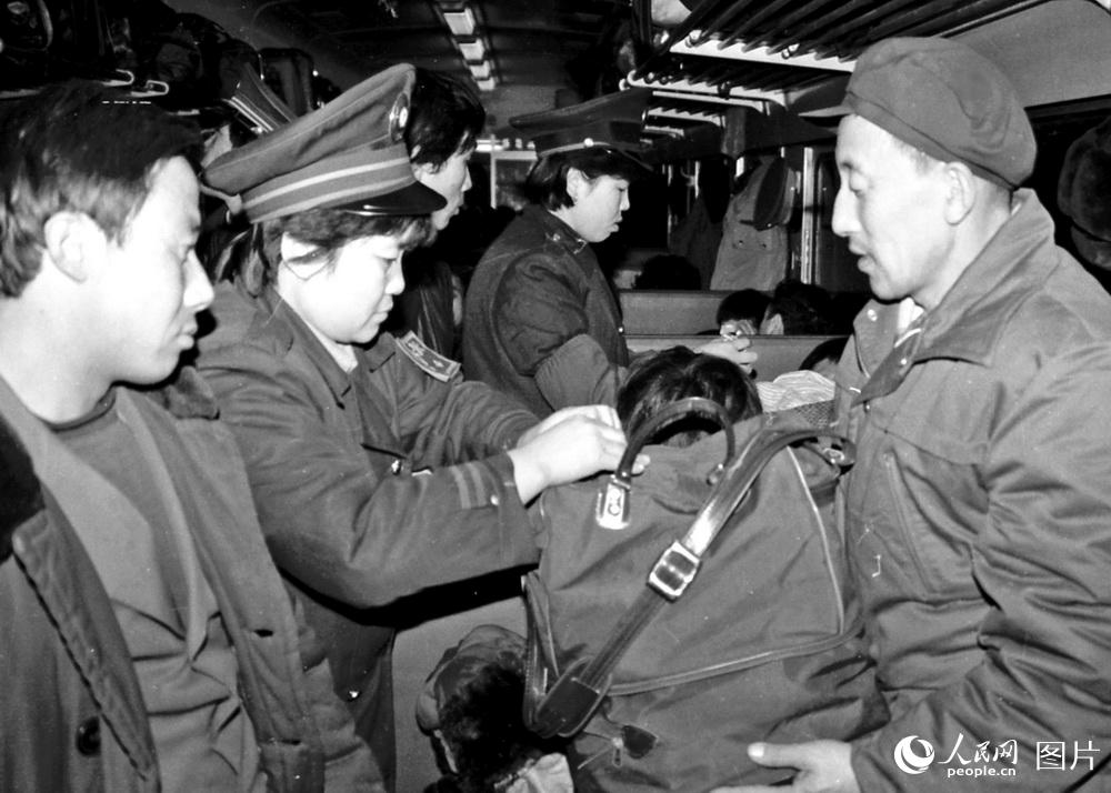 1986年2月1日，春运中，锦州列车段北京车队290次列车第二包乘组服务旅客从小事做起，列车长刘春英为旅客缝补提包。 高锦旭摄