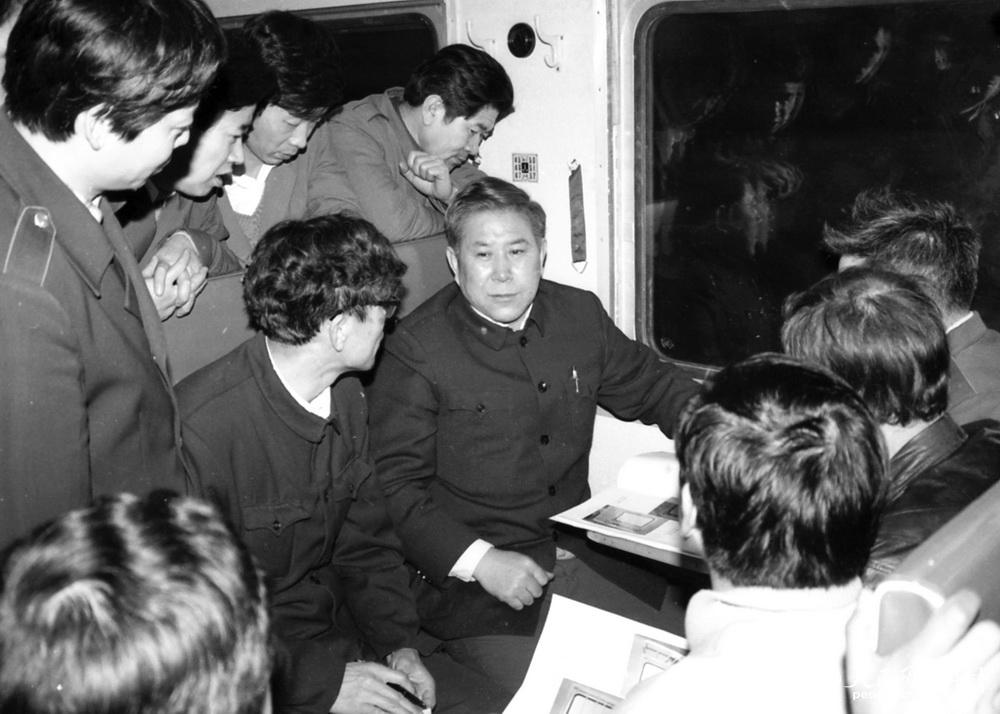 1990年2月14日，正值春运，时任铁道部长李森茂（前右一）在齐齐哈尔开往北京的40次特快列车上与旅客和乘务员谈列车改型和春运安全。高锦旭摄