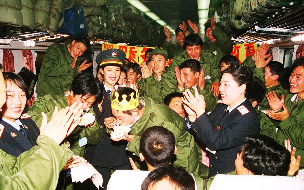 1998年12月11日，春节前夕又是新兵运输开始锦州开往北京的590次列车为新兵举办“车厢情暖新兵心”联欢会。刊登于12月15日新华每日电讯、人民日报、北京晚报、今晚报、大河报。 高锦旭摄
