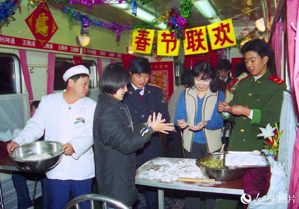 2000年2月4日，除夕夜天津开往广州的153次列车上餐车服务员和旅客忙碌的为返乡旅客包年夜水饺。高锦旭摄