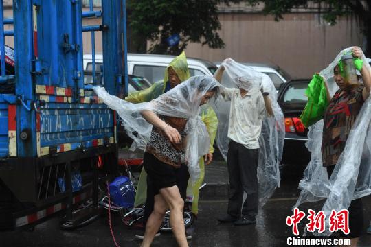 图为重庆突降暴雨民众穿着自制雨衣。　陈超 摄