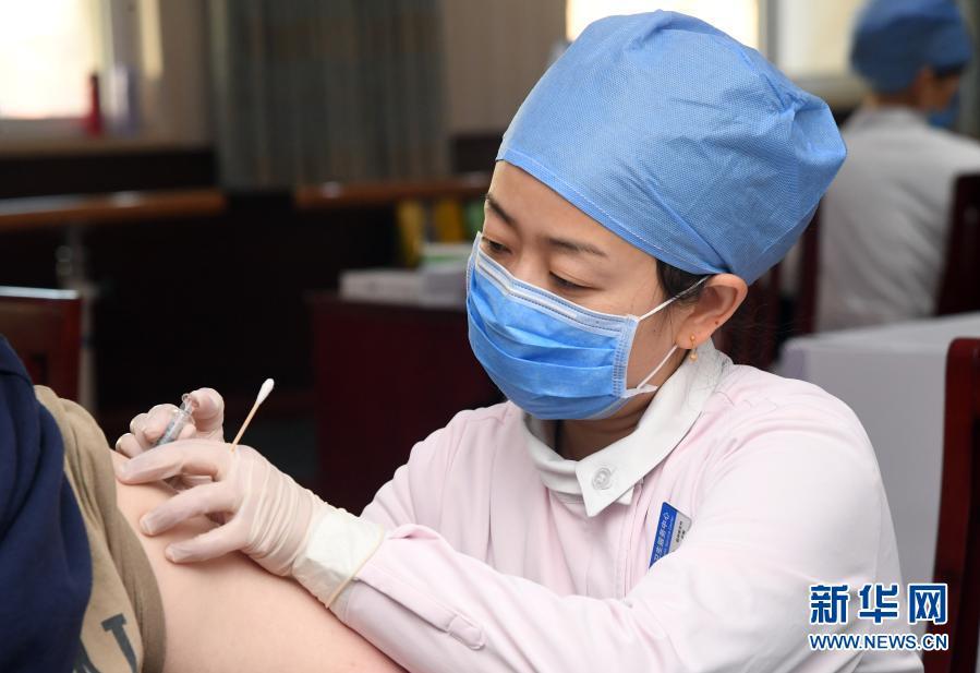 1月6日,在北京市海淀区花园路街道临时接种点登记注射室,医护人员为